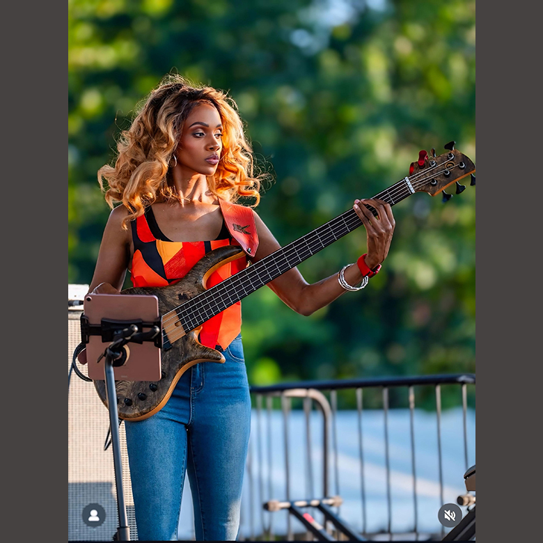 TiffsBass playing bass guitar at outdoor event