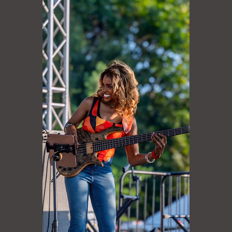 TiffsBass playing bass guitar at outdoor event